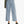 Person wearing light blue jeans and black shoes on a white background
