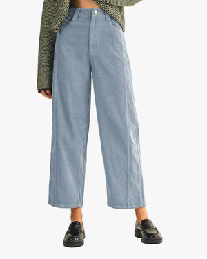 Person wearing light blue jeans and black shoes on a white background