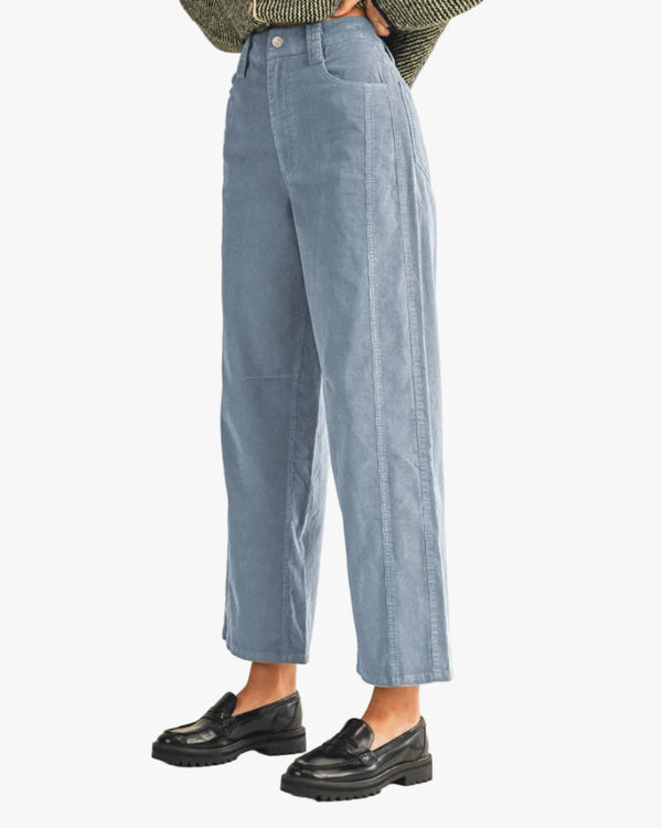 Person wearing light blue jeans and black shoes on a white background