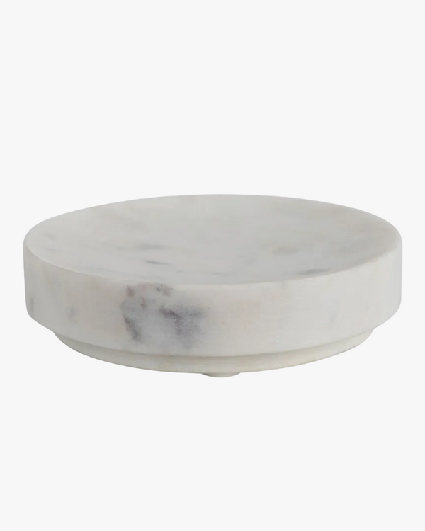 A round, white marble soap dish with a smooth surface.